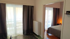 Thissio Hideaway Suite في أثينا: غرفة نوم بها سرير ونافذة كبيرة