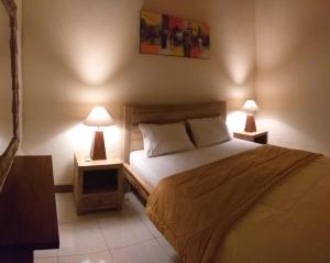 JasriにあるMama Guesthouseのベッドルーム1室(ベッド1台、テーブルにランプ2つ付)