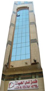 فندق ندى الضيافة في مكة المكرمة: مبنى طويل مع علامة أمامه