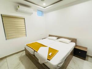 a bedroom with a large white bed with a window at Stanley's Residency in Edappally