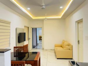 a living room with a couch and a tv at Stanley's Residency in Edappally