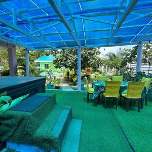 a patio with a table and chairs under a blue canopy at Joy O Hoy Beach House in Santander +14 photos
