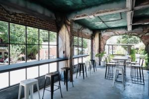 a room with tables and chairs and windows at C4 Resort in Ko Tao