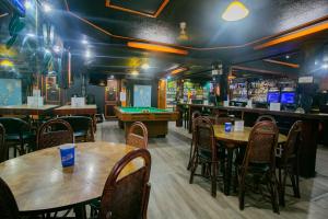 a restaurant with tables and chairs and a pool table at Slouch Hat Hotel and Restaurant in Manila