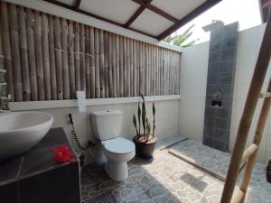 a bathroom with a toilet and a sink at Gili Moonlight bungalows in Gili Islands