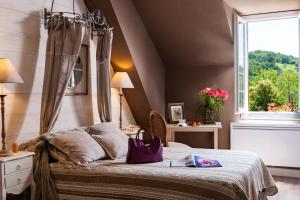 Un dormitorio con una cama con una bolsa morada. en Hostellerie Belle Rive, en Gagnac-sur-Cère