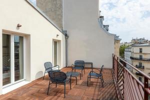 a balcony with chairs and tables on a building at Suites FL By Sweett in Paris