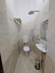 un baño con inodoro y lavabo en kailasha Inn, en Varanasi