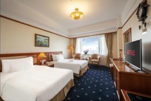 a hotel room with two beds and a flat screen tv at A25 Signature Hotel in Hanoi