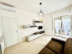 a white living room with a couch and a window at Casa Alessandra in Alassio