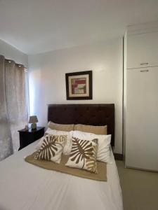 ein Schlafzimmer mit einem großen Bett mit Kissen darauf in der Unterkunft Condominium Primavera Uptown in Cagayan de Oro