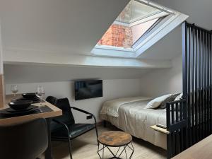 a bedroom with a bed and a desk and a window at Le Studio Bellifontain in Fontainebleau