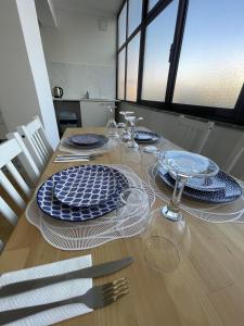 a wooden table with plates and glasses on it at Sommer Apartment in Entroncamento +9 photos