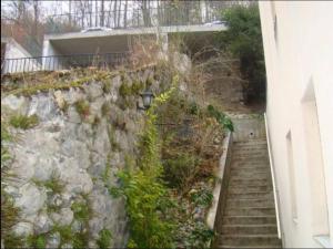 a stone wall with stairs next to a building at Appartement au centre de Barèges in Barèges +3 photos