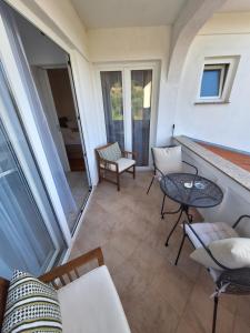 a balcony with a table and chairs on a house at Karmen in Kampor +4 photos