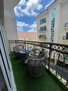 a balcony with tables and chairs and a fence at The Orai-3Bedroom Apartment in Lagos