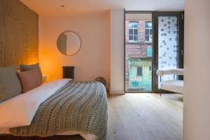 a bedroom with a bed and a large window at Townhouse East by CasaCity in Manchester