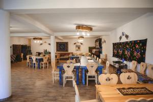 a dining room with a blue table and chairs at Casa Mariș in Vadu Izei