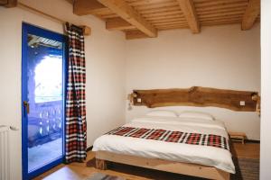 a bedroom with a bed and a sliding glass door at Casa Mariș in Vadu Izei