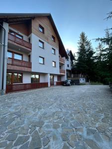a large building with a stone driveway in front of it at Montis Vlasic Apartment 2 in Vlasic