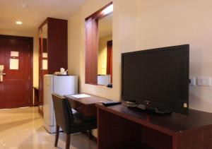 a television sitting on a desk in a room at Convenient Grand Plus Hotel Suvarnabhumi in Lat Krabang