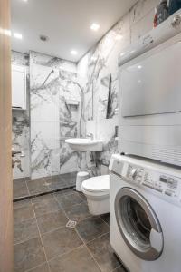 a bathroom with a washer and a toilet and a sink at Sea Side Apart in Sinemorets