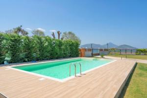 a swimming pool with a wooden deck next to a yard at Lago Di Bourtzi in Áyios Nikólaos