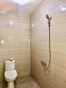 a bathroom with a shower with a toilet in it at Santika Guest House in Ubud