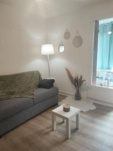 a living room with a couch and a table at studio cabine avec véranda et terrasse in Luchon