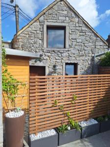 a wooden fence in front of a stone house at La Laiterie Ecaussinnes in Les Croisettes