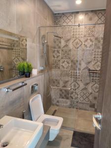 a bathroom with a shower and a toilet and a sink at Skynest Residences by Lisa's Paradise C in Nairobi