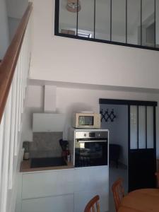 a kitchen with a staircase with a microwave on a stove at Maison avec jardin privatif à 1Km4 de la plage in Merlimont