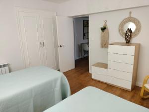 a bedroom with a bed and a dresser and a mirror at Casa Tito 2 in Santo Domingo de la Calzada