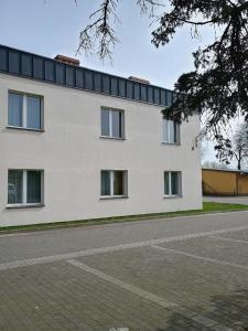 un bâtiment blanc avec des fenêtres sur le côté d'une route dans l'établissement Baltic Resort Marina, à Darłówko 6 autres photos