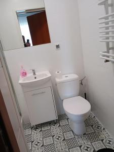une salle de bains blanche avec toilettes et lavabo dans l'établissement Baltic Resort Marina, à Darłówko