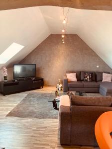 a living room with a couch and a tv at CHAMBRE et JARDIN Village au bord de l eau Cour et Garage privés in Marcilly-sur-Seine +11 photos