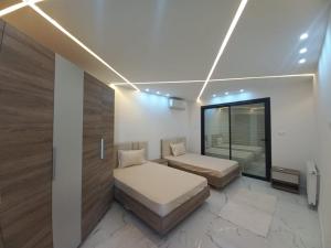 a bedroom with two beds and a window at Villa LINA Djerba Haut Standing in Aghīr