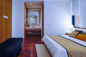 a bedroom with a bed and a bathroom with a sink at Villa Mamakami - 3BR Luxury Villa in Canggu in Canggu