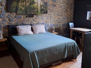 a bedroom with a bed with blue sheets and pillows at La Laiterie Ecaussinnes in Les Croisettes