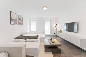 a white room with a bed and a tv at TOP Apartments - Stilvolle Wohnung im Stadtzentrum - Loggia - Kingsize Bett - Smart TV - Netflix - 60qm - 24h Check-In in Ludwigsburg
