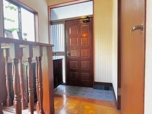 横滨2階建1棟貸しの寝室4部屋 無料高速Wi-Fi的走廊上设有木门和楼梯