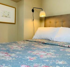 a bedroom with a bed with a lamp on it at Copper Miner’s Cottage in Beddgelert