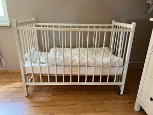 ein weißes Kinderbett mit einer weißen Decke in einem Zimmer in der Unterkunft Ferienhaus Bartelshagen 1 in Marlow