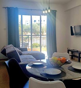 una sala de estar con un sofá y una mesa en Melania Modern Apart with pool near CORAL BAY, Pafos, en Peyia