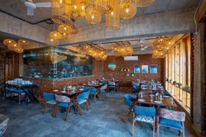 a dining room with tables and chairs and chandeliers at The Cozy Acorn Resort in Patwa Dunga