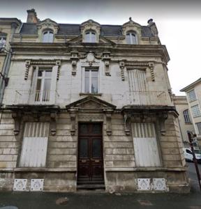 an old stone building with a door on a street at CHTX Hôtel particulier Albert Ier in Châteauroux
