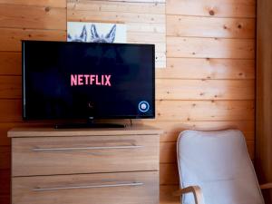 einen TV auf einer Kommode in einem Zimmer in der Unterkunft Pochard Lodge Lakeside Fishing Parking Pass The Keys in South Cerney