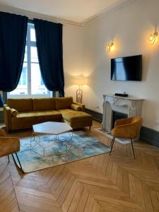 a living room with a couch and a fireplace at CHTX Hôtel particulier Albert Ier in Châteauroux