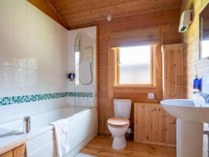 ein Badezimmer mit Badewanne, Toilette und Waschbecken in der Unterkunft Pochard Lodge Lakeside Fishing Parking Pass The Keys in South Cerney + 24 Fotos