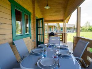 einen Tisch auf der Veranda eines Hauses in der Unterkunft Pochard Lodge Lakeside Fishing Parking Pass The Keys in South Cerney